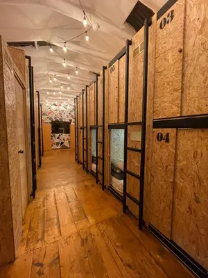 a hallway of a wine cellar with wooden floors and walls at Blacky Hostel and Apartments in Cusco