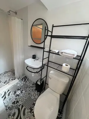 a bathroom with a toilet and a sink and a mirror at Blacky Hostel and Apartments in Cusco