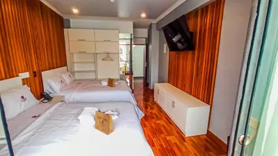 a bedroom with two beds and a tv on the wall at Resort la Fogata Cieneguilla in Cieneguilla