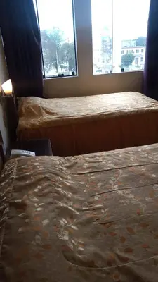 a hotel room with two beds and a window at Hotel Internacional in Lima