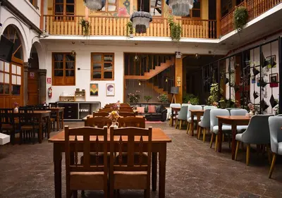 a restaurant with tables and chairs in a building at Nodo Cusco Garcilaso in Cusco