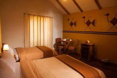a hotel room with two beds and a table at Eureka San Blas in Cusco