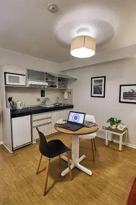 a kitchen with a table with a laptop on it at La Paz Apart Hotel in Lima