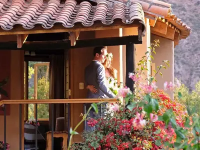 a bride and groom standing on the porch of a house at Willka T'ika in Urubamba