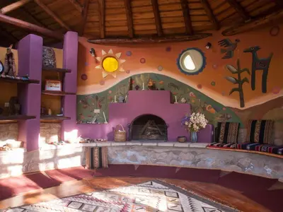 a living room with a purple wall with a fireplace at Willka T'ika in Urubamba
