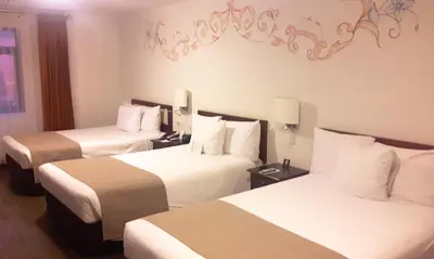a hotel room with two beds with white sheets at Wyndham Costa del Sol Cusco in Cusco