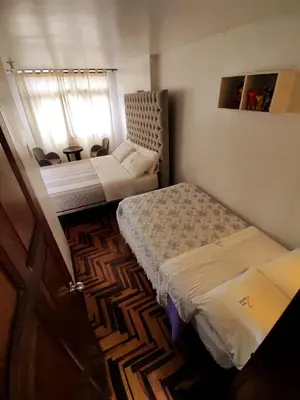 a small bedroom with two beds and a window at Casita Libertad Chorrillos in Lima