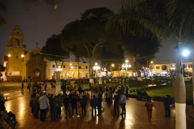 a group of people walking down a street at night at Casita Libertad Chorrillos in Lima
