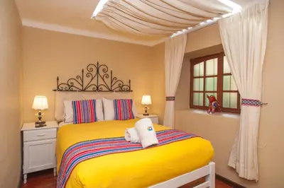 a bedroom with a yellow bed with towels on it at Casa Saphi in Cusco