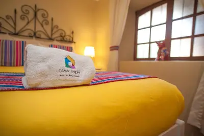 a yellow bed with a pillow on top of it at Casa Saphi in Cusco