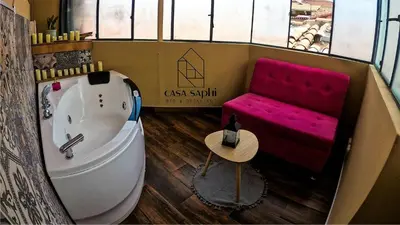 a bathroom with a tub and a pink bench at Casa Saphi in Cusco