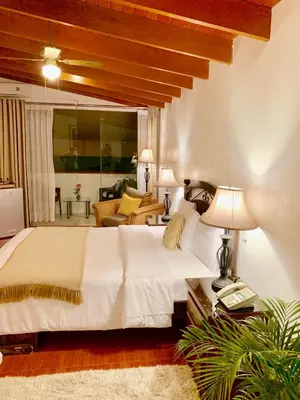 a bedroom with a large bed and a living room at Casa Bella Boutique Hotel San Isidro in Lima