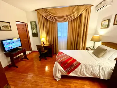 a hotel room with a bed and a television at Casa Bella Boutique Hotel San Isidro in Lima
