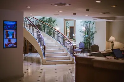 a spiral staircase in a lobby with a stair case at Los Tallanes Hotel & Suites in Lima