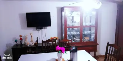 a dining room with a table and a tv on a wall at La Casa del Che Fernando in Lima