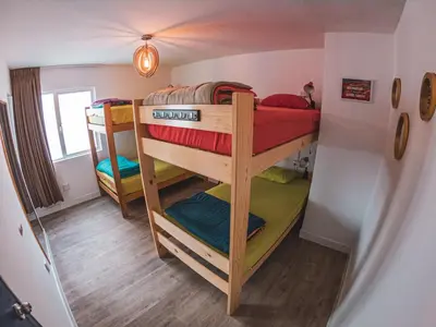 a bedroom with two bunk beds in a room at Alpes Lima Kennedy Hostel in Lima