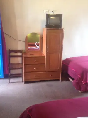 a bedroom with a bed and a dresser with a tv on it at Casa Grande Colonial Palace in Cusco