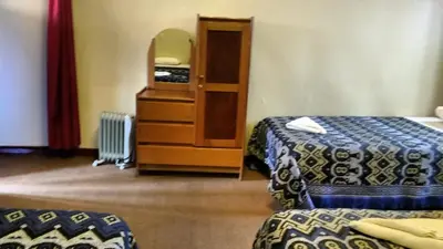 a hotel room with two beds and a dresser at Casa Grande Colonial Palace in Cusco