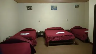 two beds in a room with red sheets at Casa Grande Colonial Palace in Cusco