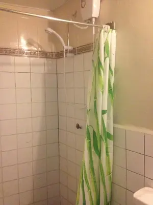 a bathroom with a shower with a green shower curtain at Casa Grande Colonial Palace in Cusco