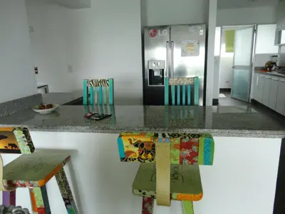 a kitchen with a counter with two chairs and a refrigerator at San Borja, bello apartamento in Lima