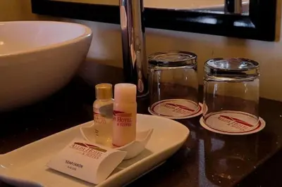 a bathroom counter with a sink and a plate with moisturizers at Allpa Hotel & Suites in Lima