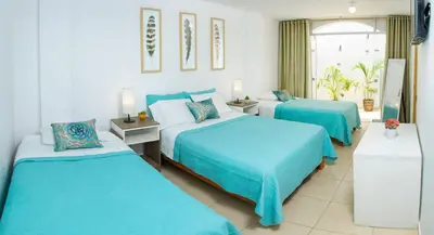 a hotel room with two beds and a window at El Huerto Hostel in Ica