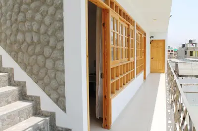 a hallway of a house with stairs and a door at El Huerto Hostel in Ica