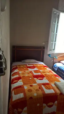 a bed with a quilt on it in a bedroom at Habitaciones para Estudiantes Y/o Mochileros in Lima