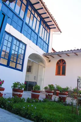 a building with potted plants in front of it at Hotel Limacpampa in Cusco