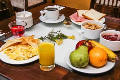 a table topped with plates of breakfast foods and drinks at Hotel Limacpampa in Cusco