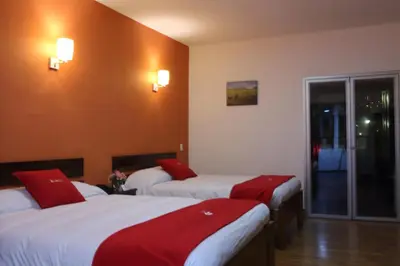 a hotel room with two beds with red pillows at Hotel Limacpampa in Cusco