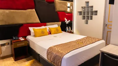 a bedroom with a large bed with yellow and red pillows at Montreal Magdalena Del Mar Hotel in Lima