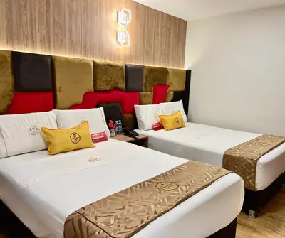 a hotel room with two beds with yellow and red pillows at Montreal Magdalena Del Mar Hotel in Lima