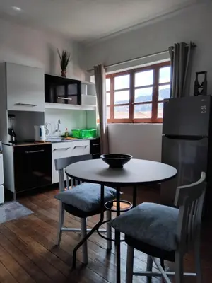 a kitchen with a table and chairs and a refrigerator at Studio in historic center Cusco in Cusco
