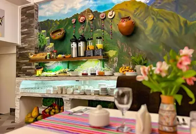 a table in a restaurant with a painting on the wall at Hotel Machupicchu Adventure in Machu Picchu