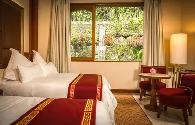 a hotel room with two beds and a window at Sumaq Machu Picchu Hotel in Machu Picchu