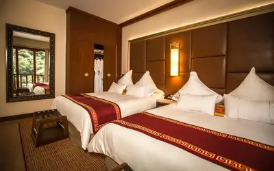 a hotel room with two beds and a mirror at Sumaq Machu Picchu Hotel in Machu Picchu