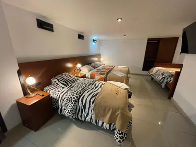 a hotel room with two beds and a bed istgquartered at Mama's House in Cusco