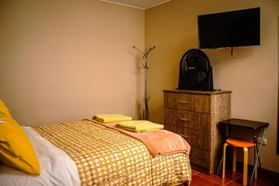 a bedroom with a bed and a flat screen tv at Del Valle House in Ica