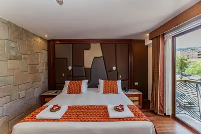 a bedroom with a large bed and a large window at Yawar Inka Hotel in Cusco