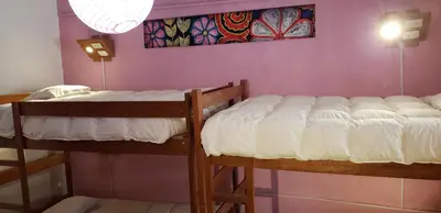 a bedroom with two bunk beds in a room at Pirwa Backpackers Colonial in Cusco