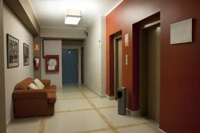 a hallway in a hospital with a chair and a door at Kamana Hotel in Lima