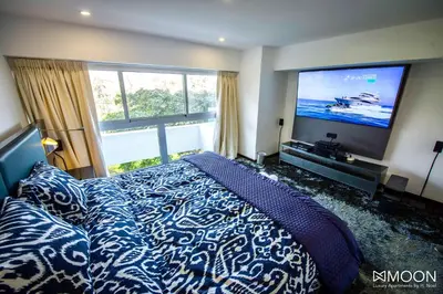 a bedroom with a bed and a large screen television at Moon Luxury Apartments in Lima