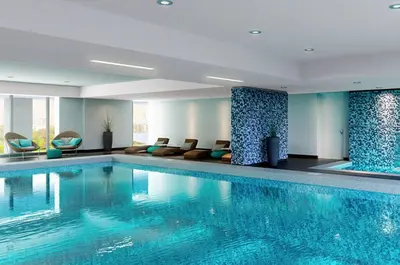a large swimming pool in a hotel room with chairs at Moon Luxury Apartments in Lima