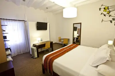 a hotel room with a bed and a desk and a television at Tierra Viva Cusco Saphi Hotel in Cusco
