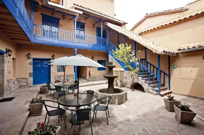a patio with a table and chairs and an umbrella at Tierra Viva Cusco Saphi Hotel in Cusco