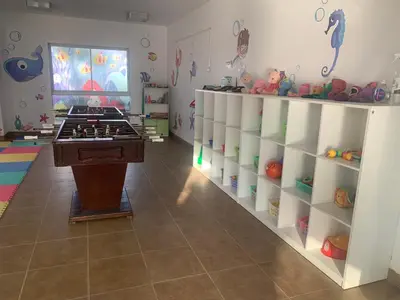 a childs room with white shelves and a table in the middle at La Casa del Jota in Asia