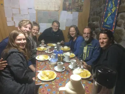 a group of people sitting around a table eating food at Wichana Wasi in Cusco