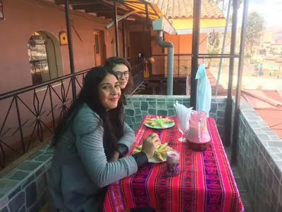 two people sitting at a table with a plate of food at Wichana Wasi in Cusco